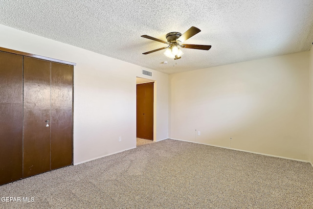 unfurnished bedroom featuring ceiling fan, carpet floors, a textured ceiling, and a closet