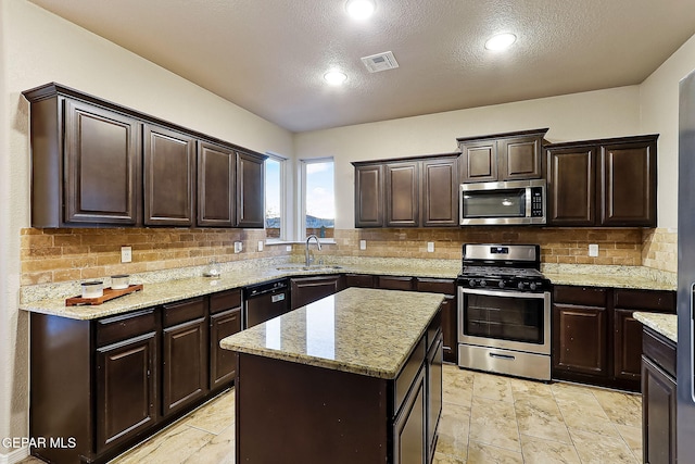 kitchen with stainless steel appliances, tasteful backsplash, a center island, and sink