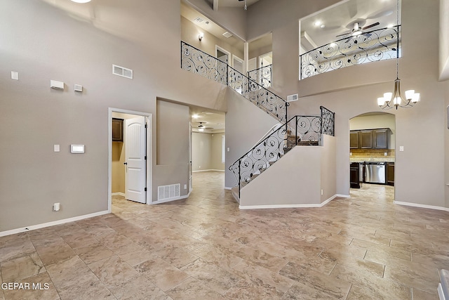 interior space with ceiling fan with notable chandelier