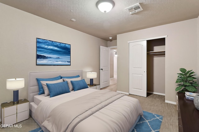 bedroom featuring light hardwood / wood-style floors, a closet, and a textured ceiling