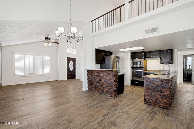 kitchen featuring sink, appliances with stainless steel finishes, dark brown cabinets, a textured ceiling, and ceiling fan with notable chandelier