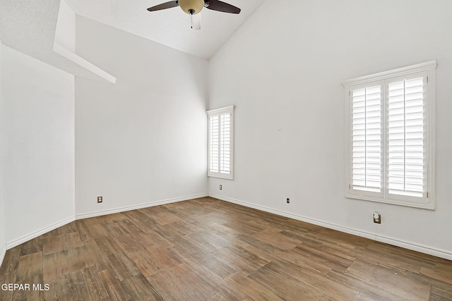 unfurnished room featuring hardwood / wood-style floors, high vaulted ceiling, and ceiling fan