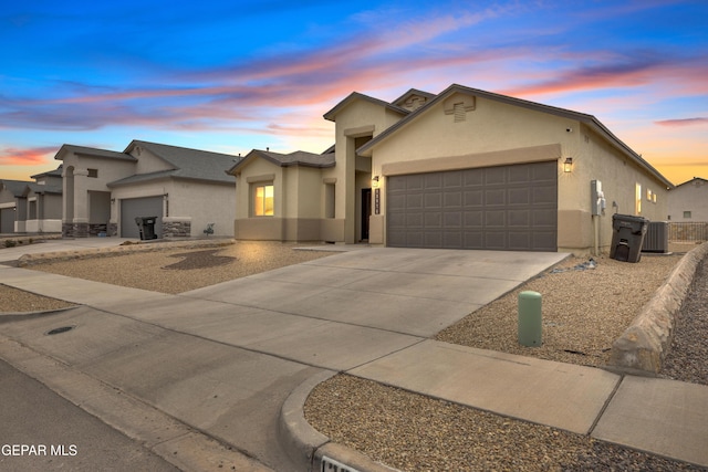 view of front of property with central AC unit and a garage