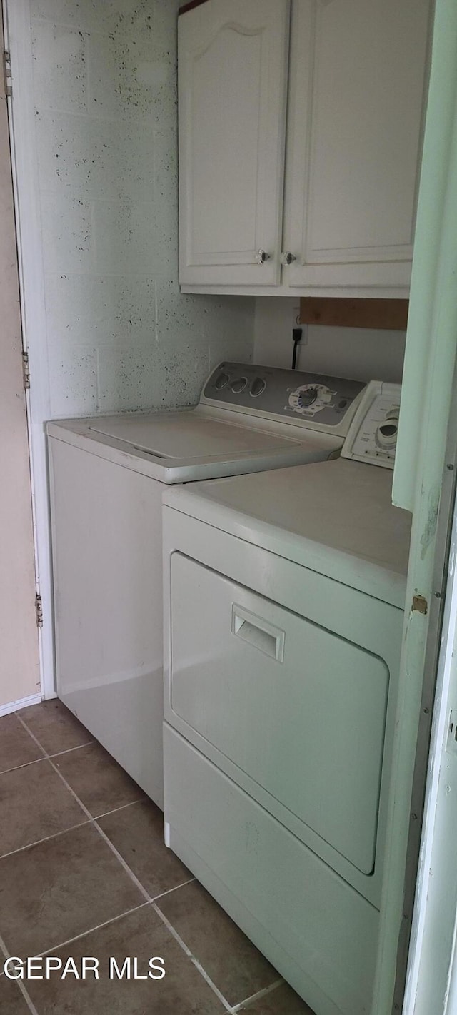 clothes washing area featuring cabinets, independent washer and dryer, and dark tile patterned floors