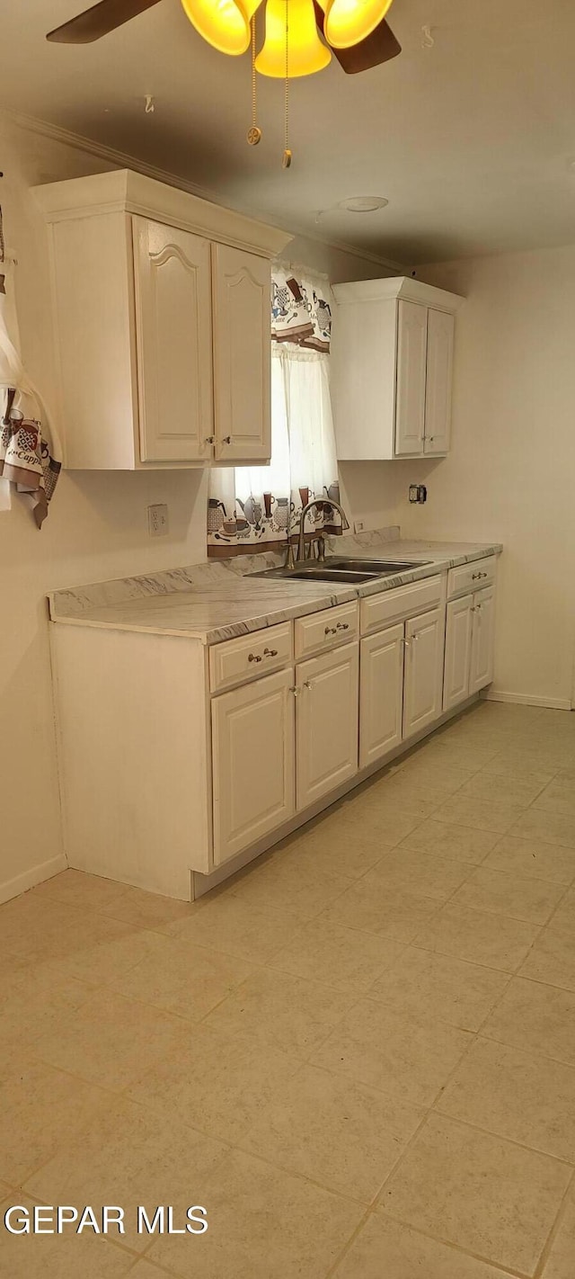 kitchen with ceiling fan, sink, and white cabinets