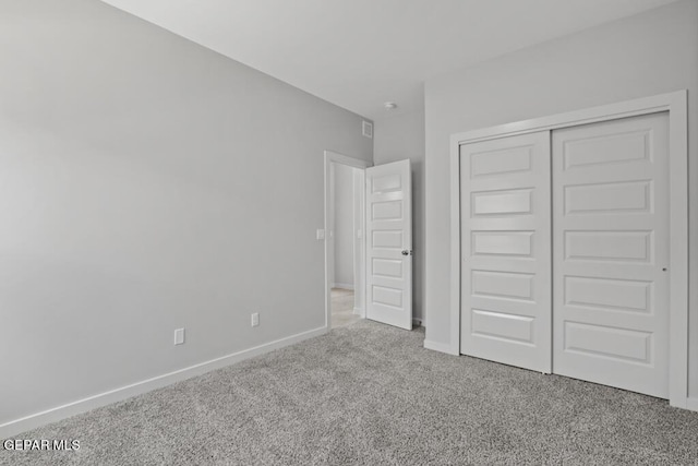 unfurnished bedroom with light carpet and a closet