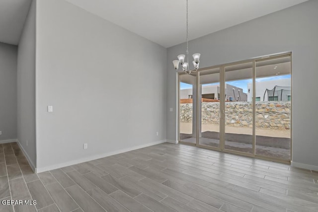 unfurnished room with a chandelier and light hardwood / wood-style flooring