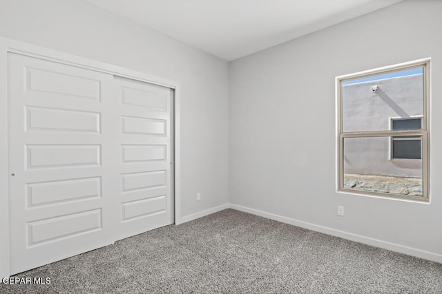 unfurnished bedroom featuring carpet flooring and a closet