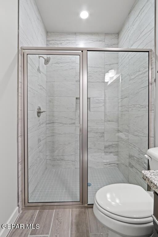 bathroom with vanity, a shower with shower door, and toilet