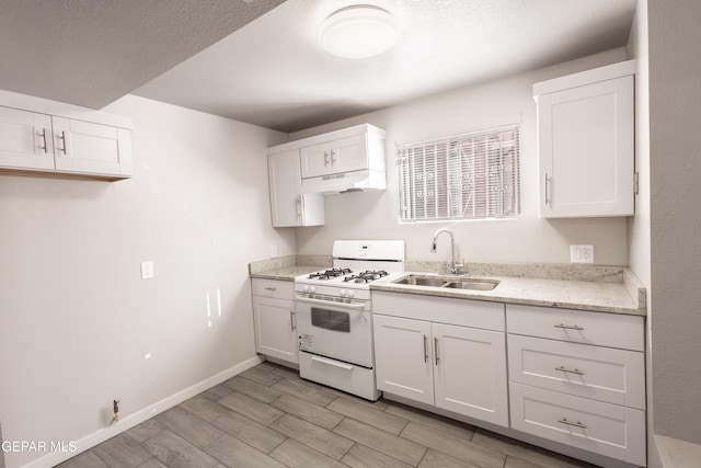 kitchen featuring sink, white range with gas stovetop, and white cabinetry