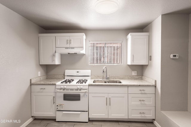 kitchen featuring sink, white cabinetry, light stone countertops, and white gas range oven