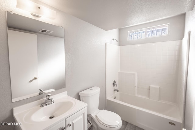 full bathroom featuring vanity, tub / shower combination, toilet, and a textured ceiling