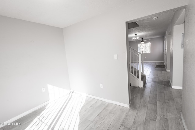 unfurnished room with hardwood / wood-style flooring and a textured ceiling