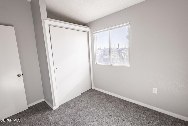 unfurnished bedroom with carpet, a closet, and a textured ceiling