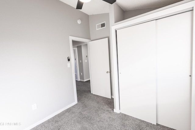 unfurnished bedroom with ceiling fan, carpet flooring, vaulted ceiling, and a closet