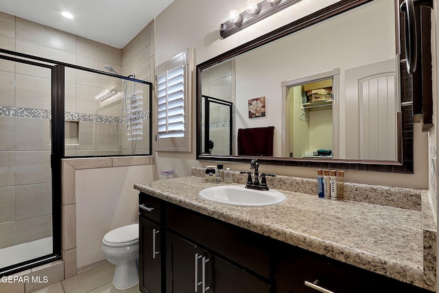 bathroom with vanity, tile patterned floors, toilet, and walk in shower