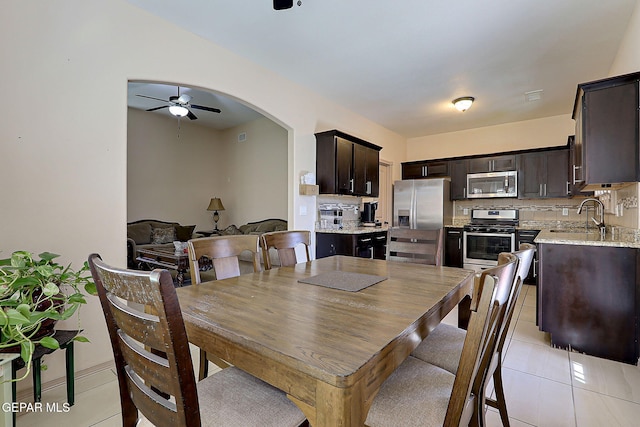 dining area with ceiling fan, sink, and light tile patterned floors