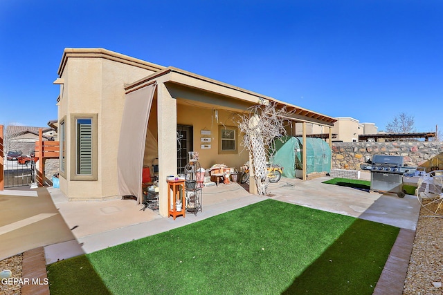 rear view of property featuring a patio area and a lawn