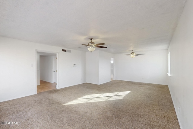 carpeted empty room featuring a textured ceiling