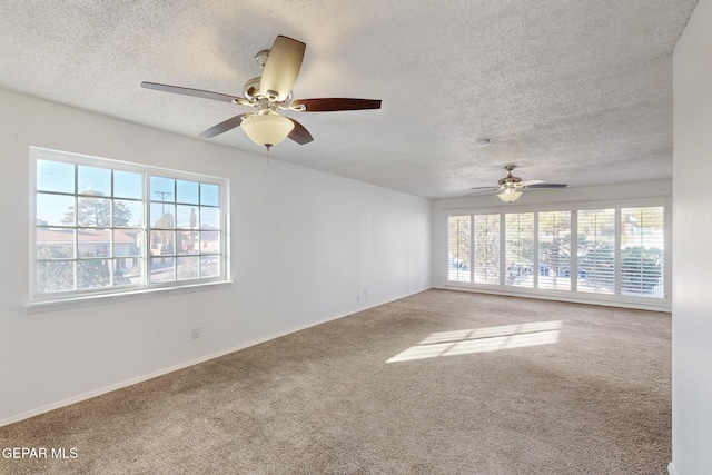 carpeted spare room with ceiling fan and a textured ceiling