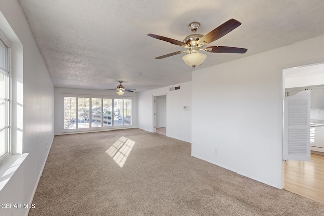 unfurnished living room featuring light colored carpet and a textured ceiling