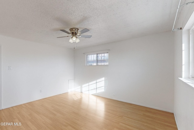 empty room featuring ceiling fan, light hardwood / wood-style floors, and a textured ceiling