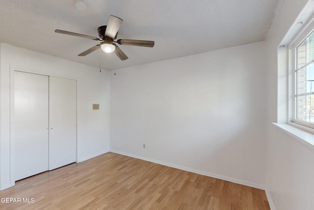 unfurnished bedroom featuring ceiling fan, light wood-type flooring, and a closet