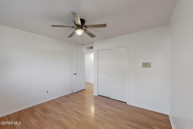 unfurnished bedroom with light hardwood / wood-style floors, a closet, and ceiling fan