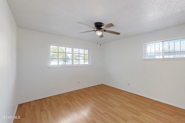 unfurnished room featuring ceiling fan, plenty of natural light, a textured ceiling, and light hardwood / wood-style flooring