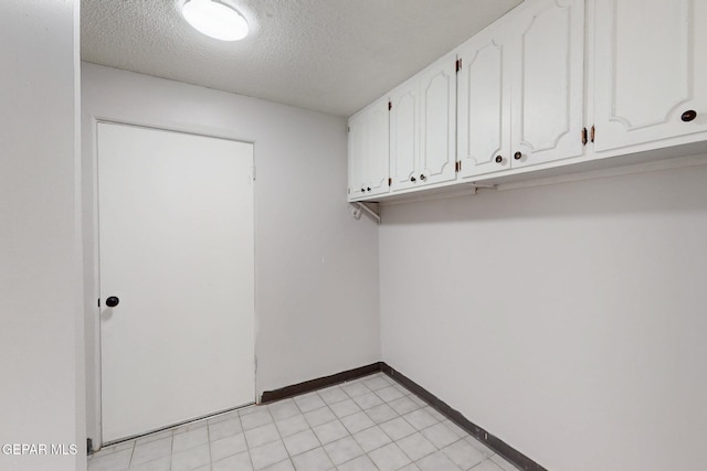 clothes washing area with a textured ceiling