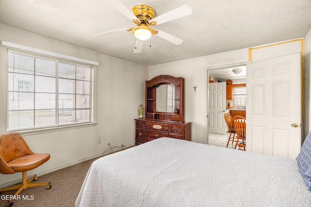 carpeted bedroom with ceiling fan and a textured ceiling