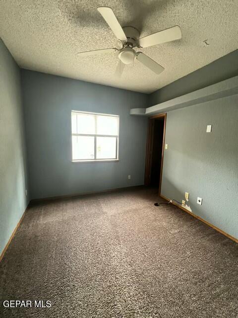 unfurnished bedroom with ceiling fan, carpet floors, and a textured ceiling