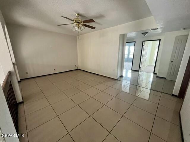 tiled empty room featuring a textured ceiling and ceiling fan