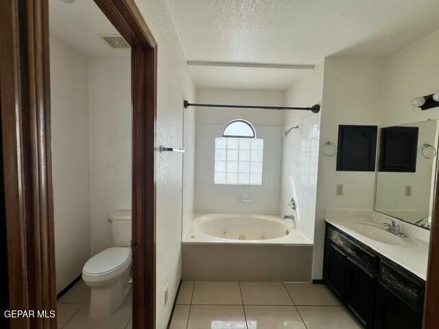 bathroom with vanity, tile patterned floors, a textured ceiling, and toilet