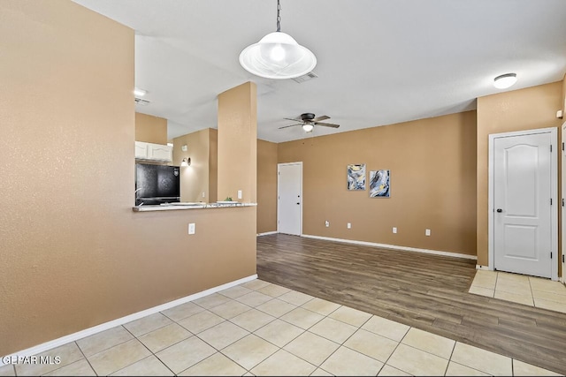 unfurnished living room featuring light tile patterned floors and ceiling fan