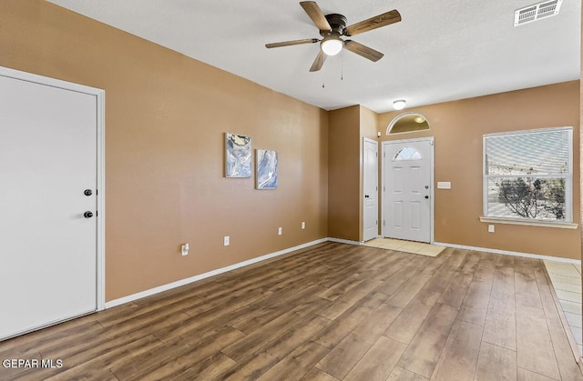 foyer entrance with ceiling fan and wood-type flooring