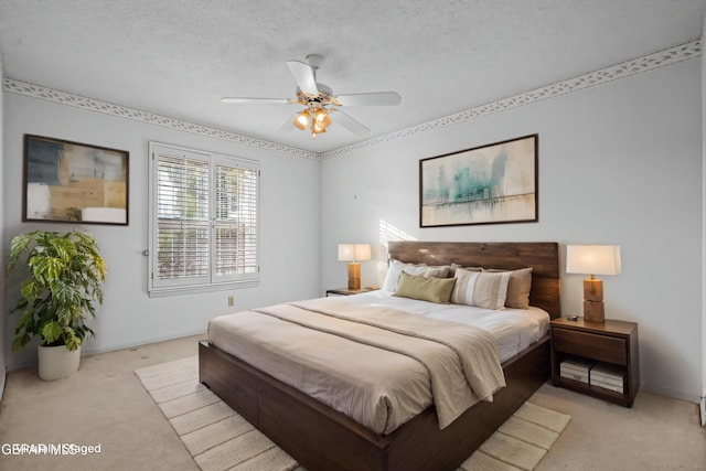 bedroom with ceiling fan, light carpet, and a textured ceiling