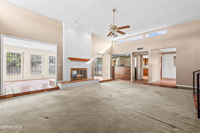 unfurnished living room featuring a towering ceiling, a textured ceiling, a fireplace, and carpet flooring