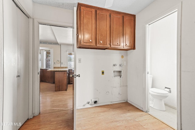 laundry room with hookup for a gas dryer, cabinets, washer hookup, electric dryer hookup, and light hardwood / wood-style flooring