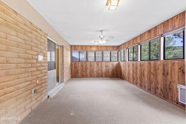 unfurnished sunroom with ceiling fan