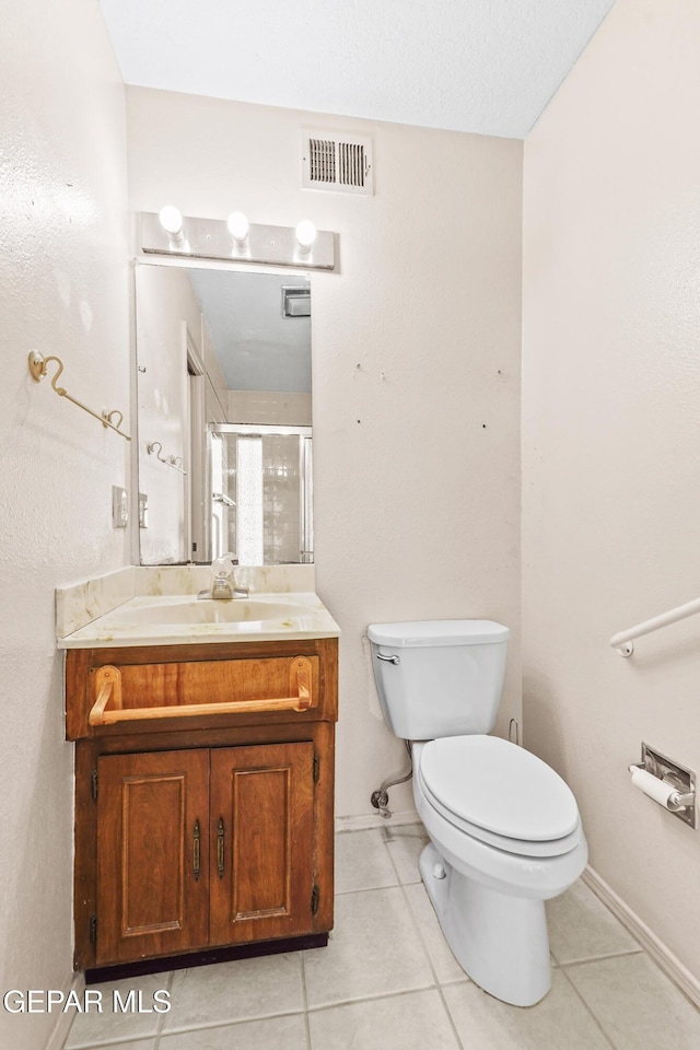 bathroom featuring vanity, toilet, and tile patterned flooring