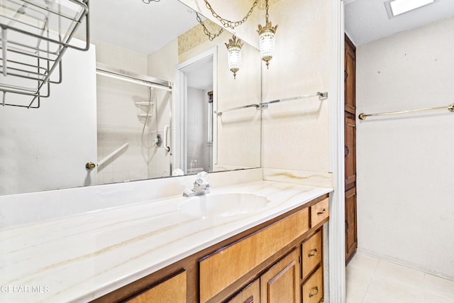 bathroom featuring a shower with door, vanity, and tile patterned floors