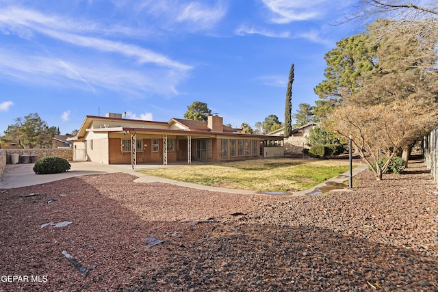 back of property with a yard and a patio area