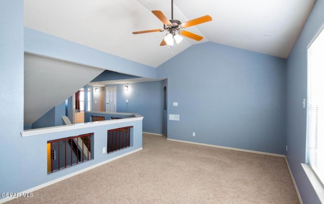 interior space with ceiling fan, lofted ceiling, carpet, and a wealth of natural light