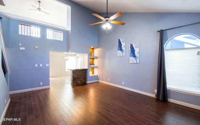 unfurnished living room featuring high vaulted ceiling, dark hardwood / wood-style floors, and ceiling fan