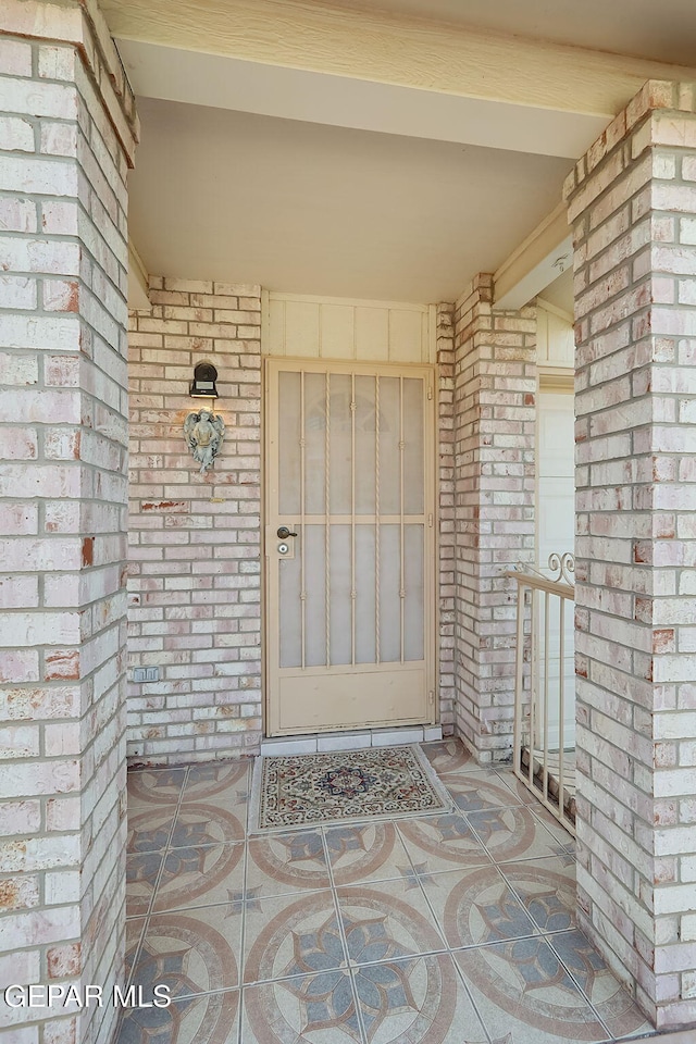 property entrance featuring brick siding