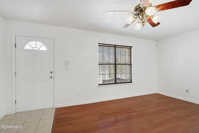 entrance foyer featuring light wood-style flooring, baseboards, ceiling fan, and a wealth of natural light