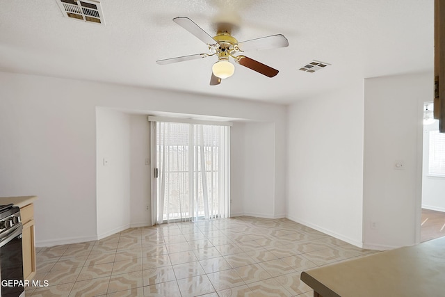 spare room featuring ceiling fan, light tile patterned flooring, visible vents, and baseboards