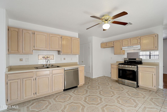 kitchen featuring under cabinet range hood, appliances with stainless steel finishes, light countertops, and a sink