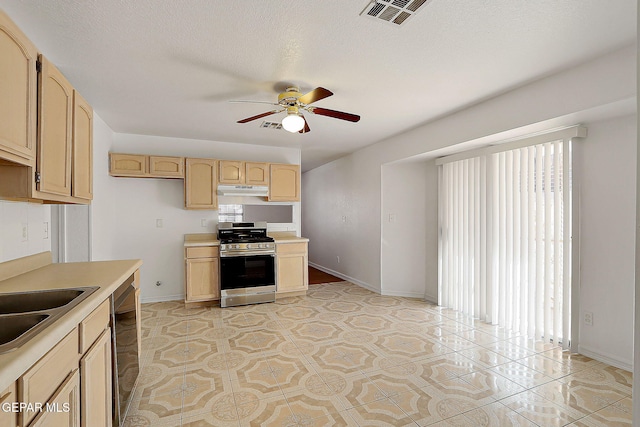 kitchen featuring stainless steel range with gas cooktop, black dishwasher, light countertops, visible vents, and light brown cabinetry